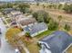 Aerial view of homes with solar panels, nestled in a community with mature trees and well-maintained landscaping, highlighting sustainability at 235 Pima Trl, Groveland, FL 34736