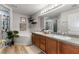 This bright bathroom features a soaking tub, glass shower, double sink and wood-look flooring at 235 Pima Trl, Groveland, FL 34736