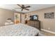 This main bedroom includes an ensuite bathroom, ceiling fan, and wood-look flooring at 235 Pima Trl, Groveland, FL 34736