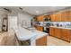 Modern kitchen showcasing stainless steel appliances, wood cabinets, a breakfast bar, and a light and airy design at 235 Pima Trl, Groveland, FL 34736