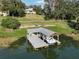 Aerial view of lake with boat lift and home, surrounded by trees at 2422 Topping Pl, Eustis, FL 32726