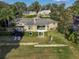 Aerial view of a brick home with a backyard patio and lush landscaping at 2422 Topping Pl, Eustis, FL 32726