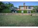 Backyard featuring a brick home exterior, a stone retaining wall and lush, green lawn at 2422 Topping Pl, Eustis, FL 32726