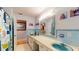 Bright bathroom featuring dual sinks, vintage blue tile, and ample counter space at 2422 Topping Pl, Eustis, FL 32726