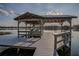 Boat lift on a lake with covered seating area and open deck at 2422 Topping Pl, Eustis, FL 32726