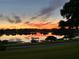 Scenic lake view at sunset, featuring a boat dock and the tranquil waterfront setting at 2422 Topping Pl, Eustis, FL 32726