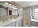 Bathroom featuring a double sink vanity, shower, separate soaking tub, and neutral tones at 25073 Riverwalk Dr, Leesburg, FL 34748