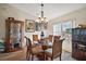 Elegant dining room featuring a glass-top table, chandelier, and hardwood floors, perfect for entertaining guests at 25073 Riverwalk Dr, Leesburg, FL 34748