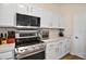 Well-equipped kitchen featuring modern appliances, white cabinetry, and ample counter space at 25073 Riverwalk Dr, Leesburg, FL 34748