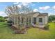 View of the screened lanai and backyard featuring lush green lawn and mature landscaping at 25073 Riverwalk Dr, Leesburg, FL 34748