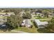 View of a well-maintained home featuring awning-covered windows, a carport, and mature trees in the neighborhood at 25605 Belle Alliance, Leesburg, FL 34748