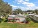 Aerial view of a well-maintained home featuring awning-covered windows and mature trees in the community at 25605 Belle Alliance, Leesburg, FL 34748