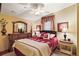 Inviting bedroom featuring a plush rug, decorative lamps, and red accents for a warm, cozy feel at 25605 Belle Alliance, Leesburg, FL 34748