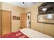 Cozy bedroom with cream and maroon bedding, a ceiling fan, and wall-mounted TV at 25605 Belle Alliance, Leesburg, FL 34748