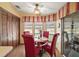 Cozy breakfast nook with a round table, four red chairs, and natural light from large windows at 25605 Belle Alliance, Leesburg, FL 34748