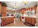 Bright kitchen featuring light wood cabinets, white countertops, and a breakfast nook with a red chair set at 25605 Belle Alliance, Leesburg, FL 34748