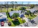 Aerial view of a well-maintained community featuring manicured lawns, palm trees, and a charming home at 26148 Glen Eagle Dr, Leesburg, FL 34748