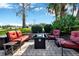 Patio with outdoor seating area and a gas fire pit, surrounded by landscaping at 26148 Glen Eagle Dr, Leesburg, FL 34748