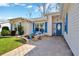 Charming entrance featuring a blue front door, decorative shutters, stone benches, and manicured landscaping at 26148 Glen Eagle Dr, Leesburg, FL 34748