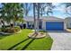 Charming single-story home featuring a vibrant blue garage door, lush landscaping, and a manicured lawn at 26148 Glen Eagle Dr, Leesburg, FL 34748