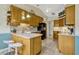 Galley kitchen features light wood cabinets, neutral countertops, and tile flooring at 26148 Glen Eagle Dr, Leesburg, FL 34748