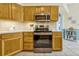 Close-up of kitchen featuring stainless steel appliances, light wood cabinets, and neutral countertops at 26148 Glen Eagle Dr, Leesburg, FL 34748