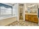 Main bathroom with a soaking tub, glass enclosed shower, and dual sink vanity at 26148 Glen Eagle Dr, Leesburg, FL 34748