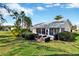 Enclosed patio area with outdoor seating, mature palms, and verdant backyard at 26148 Glen Eagle Dr, Leesburg, FL 34748