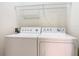 Laundry area has a white washer and dryer, with wire shelving for storage at 2917 White Cedar Cir, Kissimmee, FL 34741