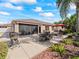 A serene view of the backyard patio, complete with landscaping, seating, and an awning, surrounded by lush greenery at 3172 Amberly Ct, The Villages, FL 32163