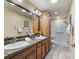 Bathroom with double sinks, granite countertops, and a modern walk-in shower at 3172 Amberly Ct, The Villages, FL 32163