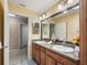 Bathroom featuring double sinks with granite countertop and modern lighting fixtures at 3172 Amberly Ct, The Villages, FL 32163