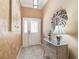 Well lit foyer with decorative table and mirror, chandelier, tiled flooring and front door at 3172 Amberly Ct, The Villages, FL 32163