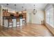 Kitchen bar area featuring pendant lighting, wood cabinets, barstool seating, and tile flooring at 3172 Amberly Ct, The Villages, FL 32163