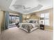 Main bedroom featuring tray ceiling, slider to lanai and a beautifully decorated space at 3172 Amberly Ct, The Villages, FL 32163