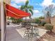 Stylish outdoor patio featuring comfortable seating, an umbrella, and tropical landscaping, perfect for relaxing at 3172 Amberly Ct, The Villages, FL 32163