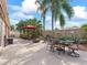 Charming outdoor patio with seating, garden, tropical trees, and an umbrella, perfect for enjoying the outdoors at 3172 Amberly Ct, The Villages, FL 32163