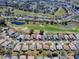 Wide aerial shot of a residential area showcasing a golf course, ponds, and neatly arranged homes at 320 Bentwood Dr, Leesburg, FL 34748