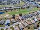 Aerial view of a neighborhood with homes surrounding a lush golf course and serene ponds at 320 Bentwood Dr, Leesburg, FL 34748