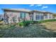 A view of the rear of the home featuring the enclosed lanai and a well maintained lawn at 320 Bentwood Dr, Leesburg, FL 34748