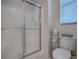 Clean bathroom featuring a glass shower, toilet, and window at 320 Bentwood Dr, Leesburg, FL 34748