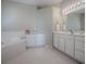 Bathroom featuring a large soaking tub, dual vanities, and lots of storage space at 320 Bentwood Dr, Leesburg, FL 34748