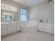 Well-lit bathroom featuring a large soaking tub, dual vanities, and a window at 320 Bentwood Dr, Leesburg, FL 34748