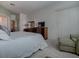 Bright bedroom featuring neutral decor, dresser, television and sitting area by the window at 320 Bentwood Dr, Leesburg, FL 34748