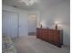 Bright bedroom with a large wooden dresser with lamps and neutral carpeting at 320 Bentwood Dr, Leesburg, FL 34748