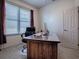 A cozy bedroom featuring a large wooden desk with a computer setup and bright natural light at 320 Bentwood Dr, Leesburg, FL 34748