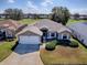 Well-kept home with two-car garage, attractive landscaping, and a view of the golf course at 320 Bentwood Dr, Leesburg, FL 34748