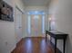 Bright foyer with hardwood floors, decorative table, and a beautifully designed glass-paneled door at 320 Bentwood Dr, Leesburg, FL 34748