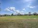 Scenic view of a lush golf course with homes in the background under a clear blue sky at 320 Bentwood Dr, Leesburg, FL 34748