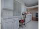 This kitchen features white cabinets and a small desk area by the window in the attached eat-in area at 320 Bentwood Dr, Leesburg, FL 34748